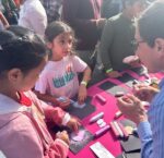young children coloring with chalk and talking to a scientist