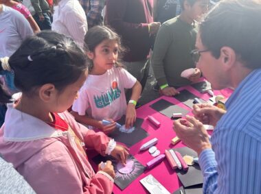 young children coloring with chalk and talking to a scientist